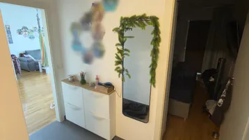 Heller Eingangsbereich mit modernem Schuhschrank, Spiegel und grauen Fliesenboden.
