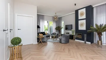 Modernes Wohnzimmer mit Fischgrätparkett, stilvollem Kamin und großen Fenstern für viel Tageslicht.