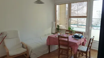 Helles Wohn- und Esszimmer mit Parkettboden, einem Esstisch und Zugang zu einem Außenbereich.