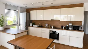 Moderne Küche mit weißen Hochglanzfronten, Holzakzenten und integrierten Geräten.