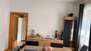 Heller Essbereich mit Holztisch, passenden Stühlen und einem Sideboard, ideal für Familienmahlzeiten.