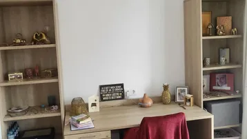 Helles Arbeitszimmer mit Schreibtisch, Regalen und Holzfußboden, ideal für Home-Office.