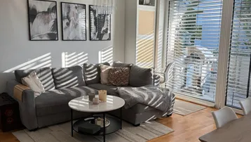 Helles Wohnzimmer mit modernem Ecksofa, Couchtisch und Zugang zum sonnigen Balkon.