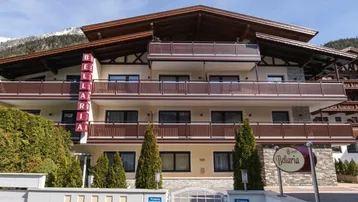 Alpines Apartmentgebäude "Bellaria" mit Balkonen und Blick auf die umliegenden Berge.
