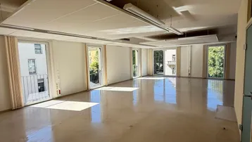 Großer, heller Büroraum mit vielen Fenstern, die viel Tageslicht hereinlassen und eine angenehme Arbeitsatmosphäre schaffen.