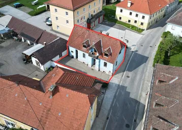 Luftaufnahme eines Hauses mit roter Umrandung, die das Grundstück in einer ländlichen Umgebung markiert.