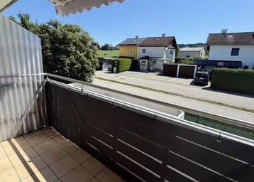 Sonniger Balkon mit Markise und Blick auf die umliegenden Wohnhäuser.
