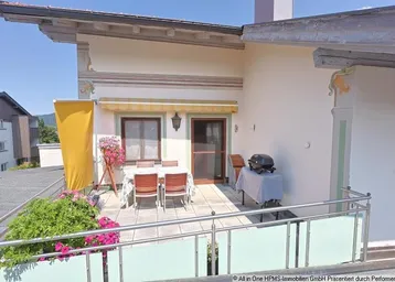 Geräumige Terrasse mit Essbereich, Grill und Blick auf die umliegende Landschaft, ideal für entspannte Stunden im Freien.