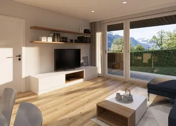 Helles Wohnzimmer mit Holzboden, großem Fenster und Blick auf die Berge und den Garten.