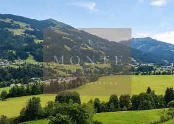 Panoramablick auf die umliegende Berglandschaft mit grünen Wiesen und einem charmanten Dorf.