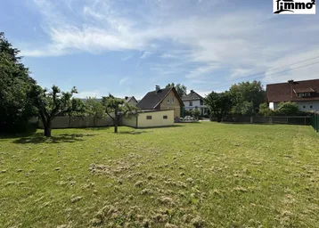 Großes, sonniges Gartengrundstück mit Rasenfläche und Baumbestand in ländlicher Umgebung.