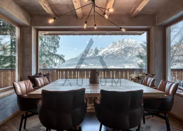 Geräumiger Essbereich mit Holztisch, bequemen Stühlen und atemberaubendem Bergblick durch große Fenster.