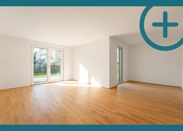 Helles, leeres Zimmer mit Parkettboden und Zugang zum Garten durch große Schiebetüren.