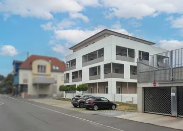 Modernes Mehrfamilienhaus mit Balkonen und Tiefgaragenzufahrt in städtischer Umgebung.