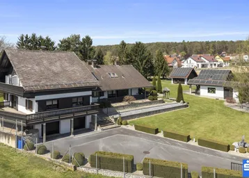 Großzügiges Anwesen mit Haupthaus, Nebengebäude und Photovoltaikanlage auf dem Dach.