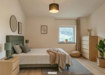 Gemütliches Schlafzimmer mit Holzboden, bequemen Möbeln und einem Fenster mit Blick ins Grüne.