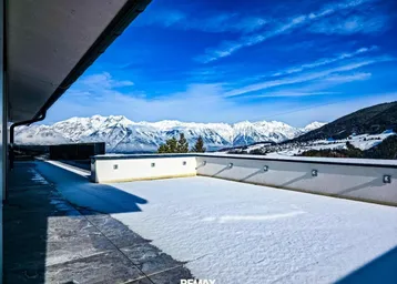 Große, schneebedeckte Terrasse mit atemberaubendem Panoramablick auf die verschneiten Berge.