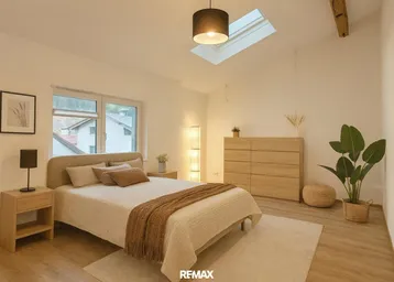 Helles Schlafzimmer mit Holzboden, gemütlichem Bett, Kommode und Dachfenster für eine angenehme Atmosphäre.