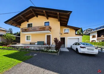 Charmantes Haus im Alpenstil mit Balkon, Garage und gepflegtem Vorgarten.