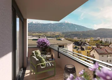 Heller Balkon mit Holzboden, Sitzgelegenheiten und atemberaubendem Bergblick am Tag.