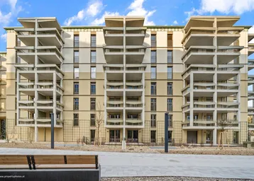 Modernes Mehrfamilienhaus mit zahlreichen Balkonen und einer gepflegten Außenanlage.