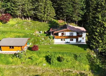 Luftaufnahme des Anwesens mit Haupthaus, Nebengebäude und umgebender Natur.