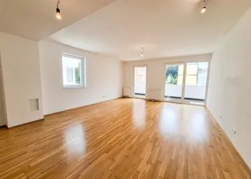 Helles, leeres Zimmer mit Parkettboden und Zugang zu einem Balkon, bereit zur Gestaltung.