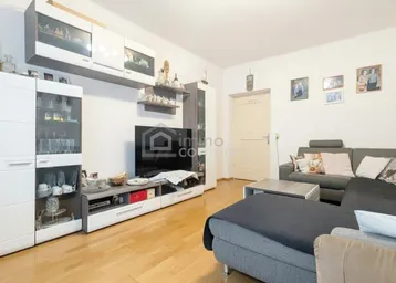 Wohnzimmer mit modernem TV-Möbel und Hängeschränken, ergänzt durch einen warmen Holzboden.