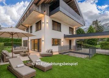 Modernes Haus mit großem Garten, möblierter Terrasse und Bergblick unter blauem Himmel.