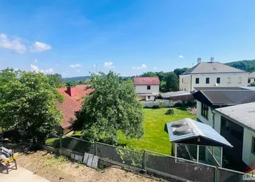 Weitläufiger Blick über die grüne Umgebung und die Dächer der benachbarten Häuser.
