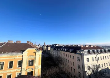 Blick über die Dächer der Stadt mit historischen Gebäuden unter blauem Himmel.