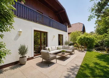 Große gepflasterte Terrasse mit bequemen Gartenmöbeln und Blick auf den grünen Gartenbereich.