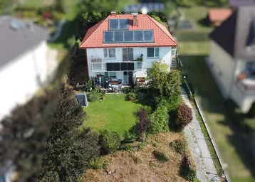 Luftaufnahme eines Hauses mit Solaranlage auf dem Dach und einem grünen Gartenbereich.