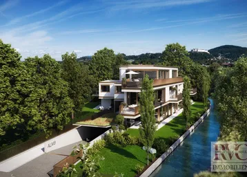 Luftaufnahme einer modernen Wohnanlage am Kanal mit Tiefgaragenzufahrt und Bergblick.