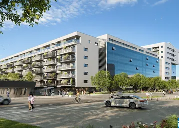 Moderne Wohnanlage mit Glasfassade und Balkonen an einer belebten Straße.