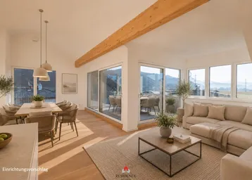 Helles, offenes Wohn- und Esszimmer mit Holzbalken, großen Fenstern und Zugang zu einer Terrasse mit Bergblick.