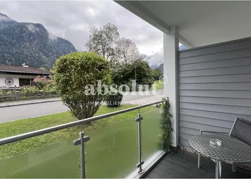 Balkon mit Sitzgelegenheiten und einem malerischen Blick auf die umliegenden Berge.