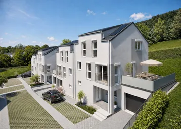 Moderne Reihenhäuser mit Balkonen, Garagen und Parkplätzen in einer ruhigen Wohngegend am Hang.