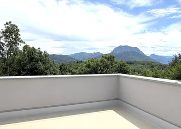 Große Dachterrasse mit weitem Panoramablick auf die Berge und grüne Wälder.