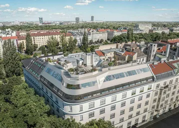 Moderne Dachgeschosswohnungen auf einem historischen Gebäude mit Blick über die Stadt.