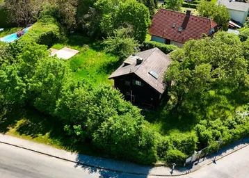 Luftaufnahme eines Hauses umgeben von viel Grün und Bäumen in einer ländlichen Umgebung.