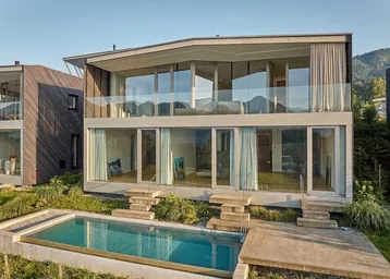 Moderne Villa mit großzügiger Glasfassade, Infinity-Pool und atemberaubendem Bergblick.