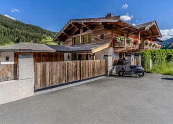 Traditionelles Holzchalet mit moderner Architektur und gepflegtem Eingangsbereich in alpiner Umgebung.