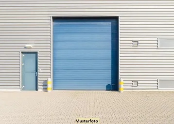 Fassade eines modernen Industriegebäudes mit großem blauen Rolltor und separatem Eingangsbereich.