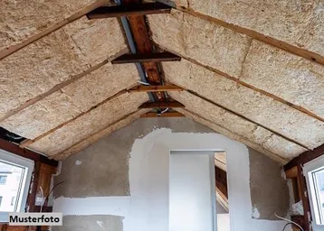 Dachgeschossraum im Rohbau mit sichtbarer Dämmung und Holzkonstruktion, bereit für den Ausbau.
