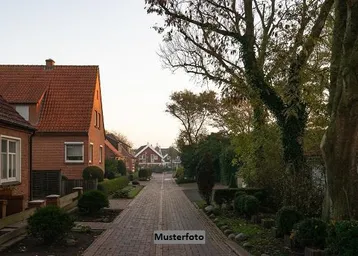 Ruhige Wohnstraße mit traditionellen Backsteinhäusern, gepflastertem Weg und grünen Gärten in einer Wohngegend.