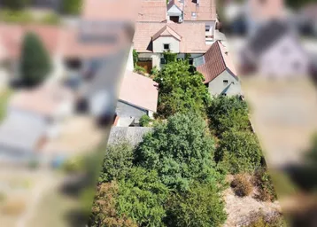 Luftaufnahme eines Anwesens mit Haus, großem Gartenbereich und umliegender Landschaft.
