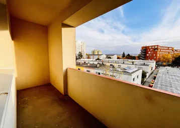 Geräumiger Balkon mit Blick auf die umliegenden Gebäude und den Himmel.