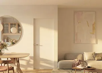 Heller offener Wohn- und Essbereich mit modernem Design, großem Spiegel und frischen Blumen.