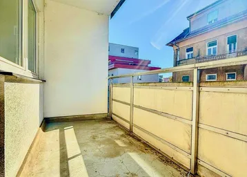 Heller Balkon mit Blick auf umliegende Gebäude und sonniger Ausrichtung.